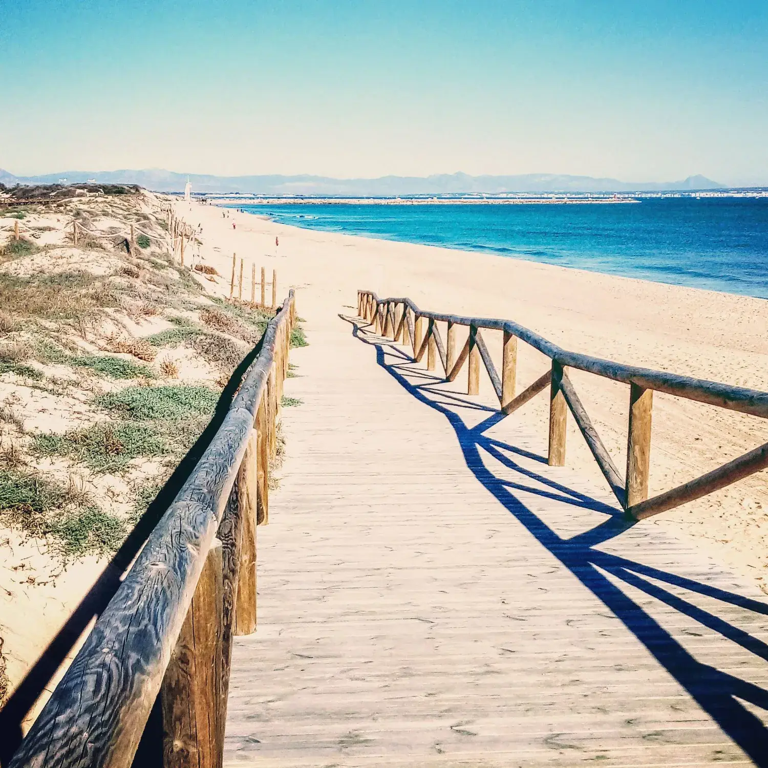 Passerelle en bois menant à la plage dels Vivers à travers les dunes