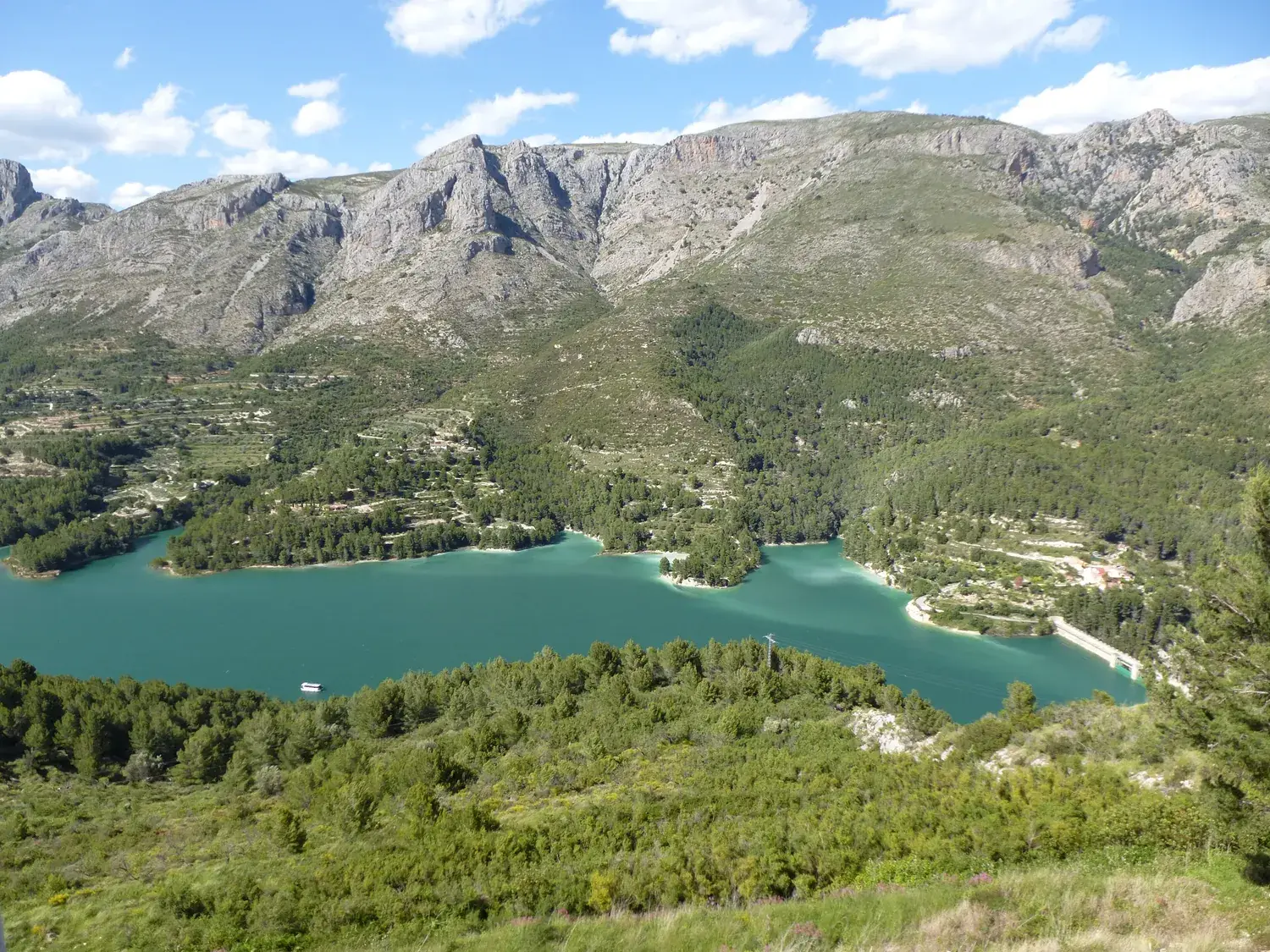 Le lac de barrage de Guadalest, d’un bleu turquoise, entouré de montagnes et de pinèdes
