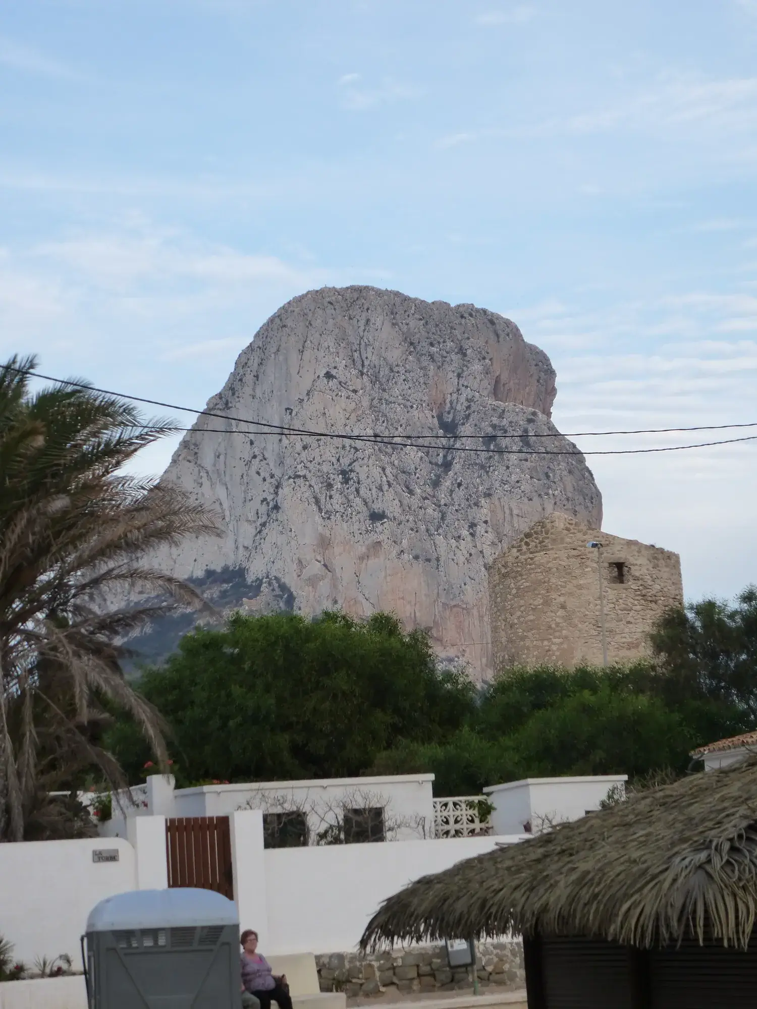 Le Peñón de Ifach se dressant derrière une tour et des palmiers à Calpe