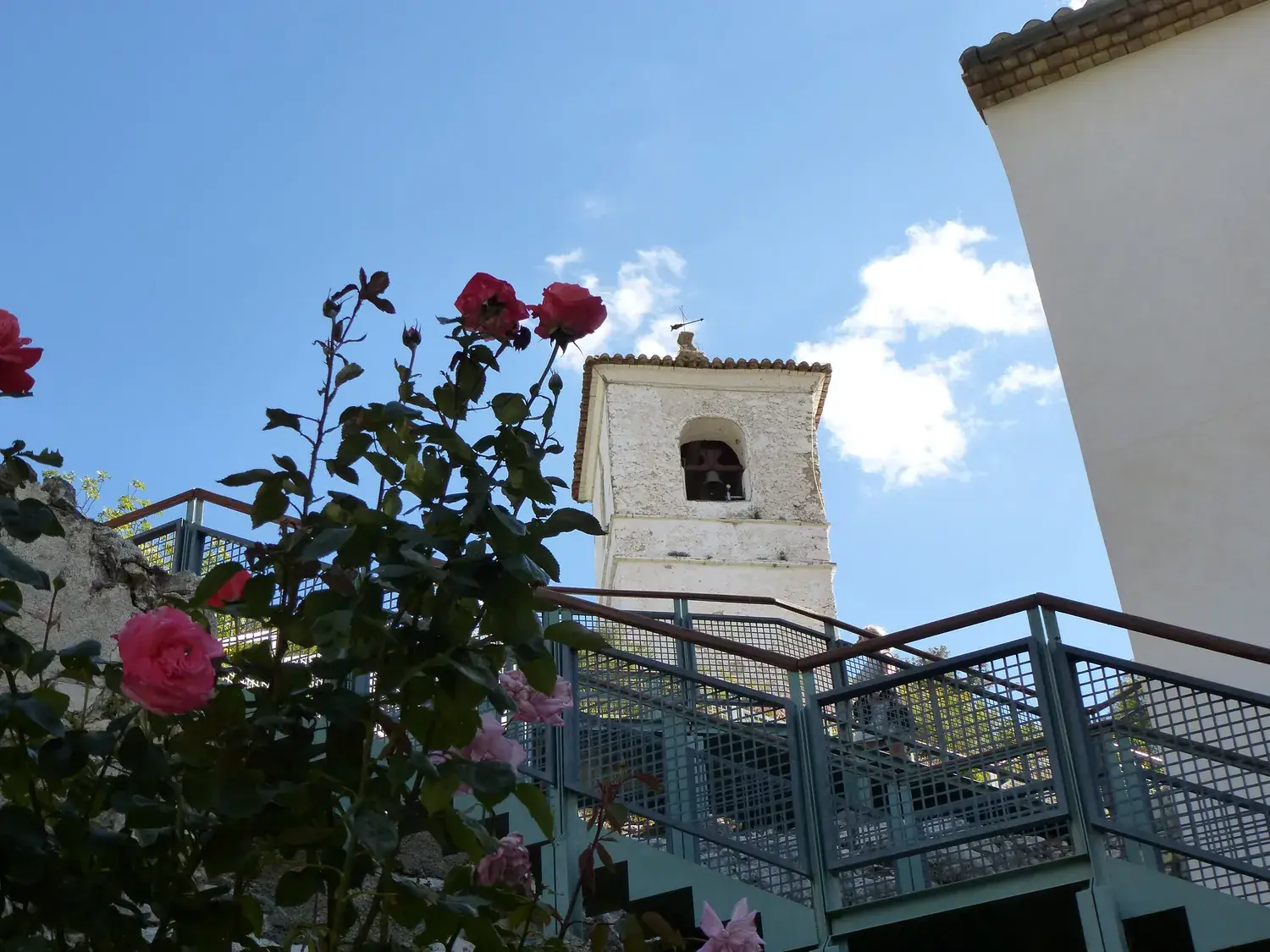 Le campanile de Guadalest vu depuis une terrasse fleurie de rosiers