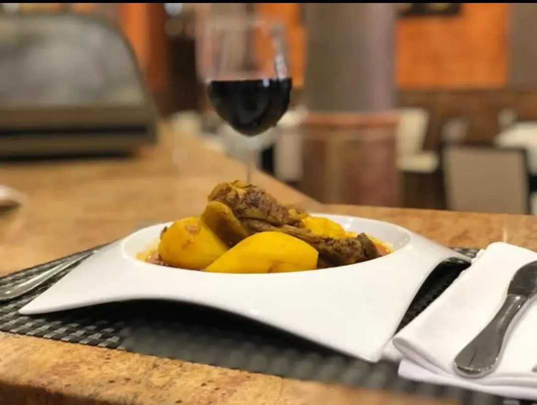 Plat servi au restaurant Punto Caliente à Benejúzar, accompagné d’un verre de vin rouge