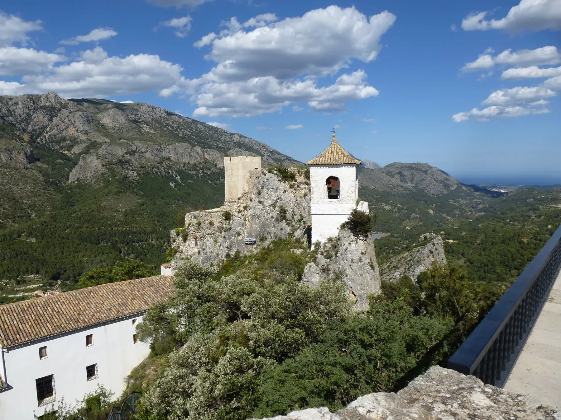 Le campanile blanc de Guadalest perché sur son rocher, avec la vallée et le lac en contrebas